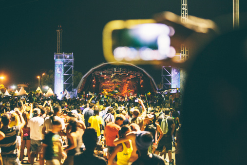 Benicassim, Spain - August 25, 2013: Someone with smartphone is recording the show while Jamaican reggae/dancehall artist Damian Marley is on stage. This event is biggest reggae festival in Europe and been around for 20 years.