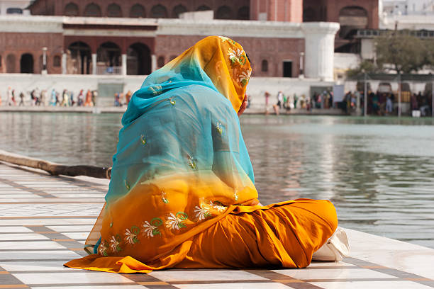 Amritsar, India - March 9, 2012: Indian woman wearing Sari praying while sitting inside the  \