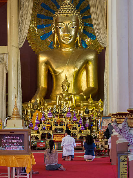 buddhistische anhänger beten vor großen buddha-statue - buddha temple wat phra sing asia stock-fotos und bilder
