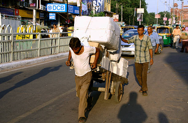Delhi, India - September 22, 2007: Man pulling cart laden with goods on September 22, 2007 in Delhi, India. Carts are commonly used to transport goods in Delhi.