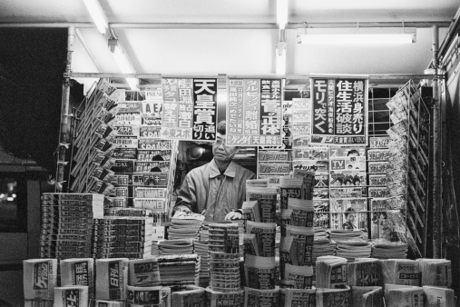 Tokyo, Japan - November, 2010 : A Japanese man organizing his newspaper and magazine stand in Tokyo, Japan.