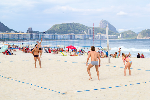 Rio de Janeiro, Brazil - October 27, 2013: Locals playing beach volley at Copacabana beach. It is one of the most famous beach in Brazil, with a wonderful view to Sugarloaf mountain. Lots of tourists visit the city looking for a good time in the tropical climate.