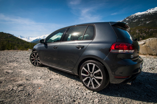 Whistler, Canada - April 1, 2013: A 2012 Volkswagen Golf GTI rests at a roadside gravel lot with the Canadian Rocky Mountains in the background. This location is near Whistler, British Columbia.