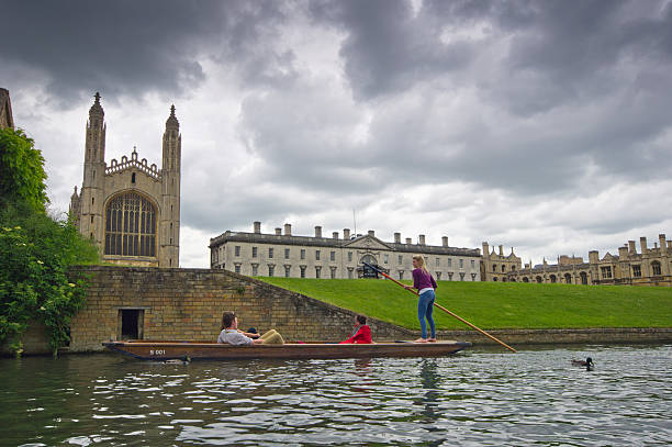 Punting on the Cam Cambridge, United Kingdom - June 16, 2013: Lazy Sunday afternoon on the River Cam in Cambridge, England, tourists on punts with tourists looking on. couple punting stock pictures, royalty-free photos & images