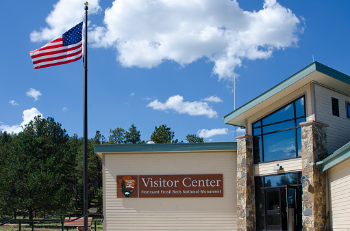 Florissant, United States - September 7, 2013: The American flag flies high at the Visitor Center at Florissant Fossil Beds National Monument.  Like many centers within the National Park system, this building houses park rangers, maps, displays and a short movie introducing the area to tourists.