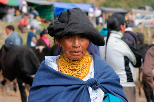 Otavalo , Ecuador - August 25, 2012: Ecuadorian ethnic women in national clothes selling farm animales on a market in the Otavalo village