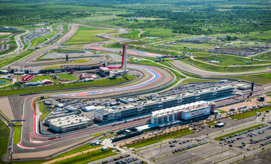 Austin, Texas, USA - April 19, 2013: Austin area aerial from helicopter withCircuit of the AmericasaA motorsports race track in foreground. MotoGPaA - Motorcycle Racing World Championship, free practice 1 in session.
