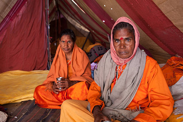 zwei weibliche sadhus im shelter camp im kumbh mela - indian ethnicity sadhu india pilgrim stock-fotos und bilder