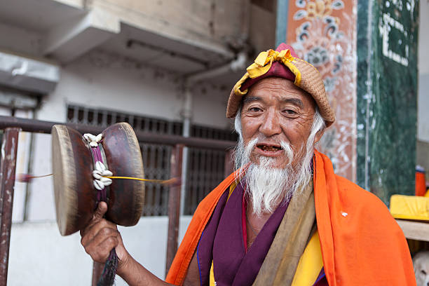 Old bhutanese monk making music in streets of Thimpu stock photo