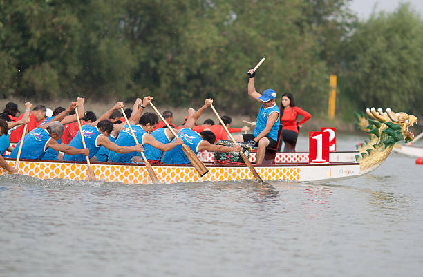 Foshan, China - November 4, 2012: Dragon Boat Racing, Foshan:In the Dongping watercourses of Foshan, teams of men in Dragon boats paddle vigorously in a competitive race, which is 2012 Foshan International Dragon Boat Races, by Chinese Dragon Boat Association (CDBA).