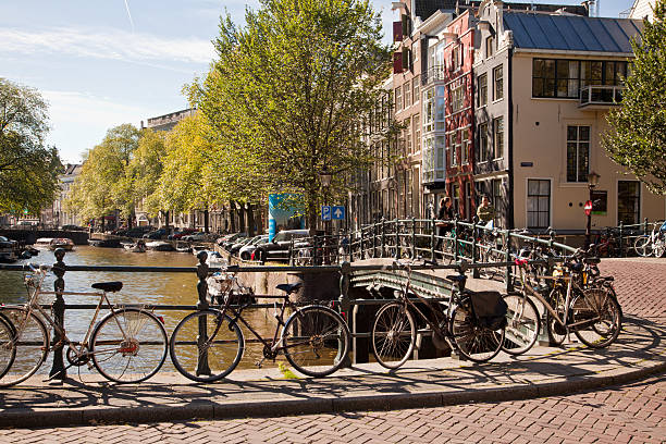 Bicicletas por um Canal em Amsterdã - foto de acervo