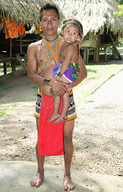 Panam Lake Alajuela, Panama - June 26, 2013: A man who was holding his daughter at the Embera Indian village in Panamanian Jungle, Panama country looking towards camera half dressed girls pictures stock pictures, royalty-free photos & images