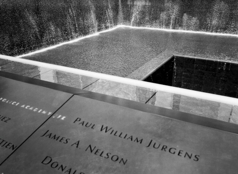 New York, USA - June 24, 2012: A view of some of the names and the central fountain at the 9/11 Memorial in New York City. The 9/11 Memorial was built to honor those who perished in the World Trade Center buildings in New York on September 11, 2011. (Scanned from black and white film.)