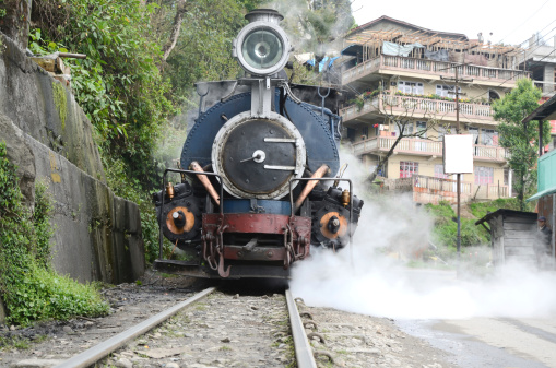 Darjeeling, West Bengal, India - October 29th, 2012: Steam engine of old Toy Train in the city railway station; engine driver on the engine.