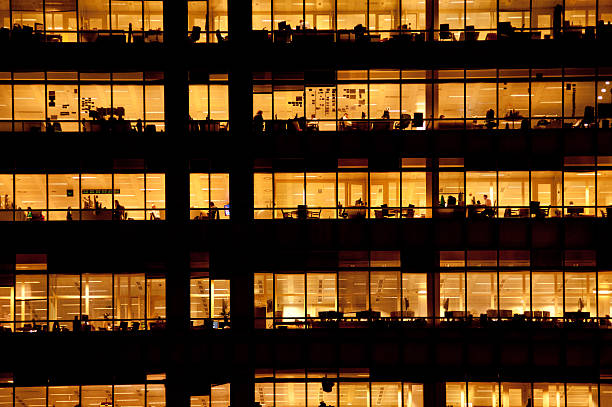 travailleurs de bureau moderne bâtiment - lighting equipment office building night city photos et images de collection