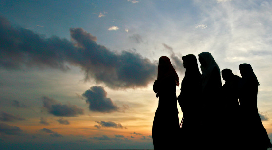 Colombo, Sri Lanka - April 13, 2010: Muslim women walk on the beach in Sri Lanka. A majority of Sri Lanka is Buddhist, but because of trade routes, Islam was introduced and can be found in many Southern Communities.