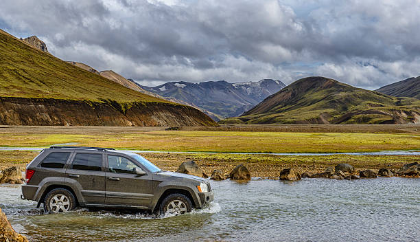 Landmannalaugar, Iceland - September 11, 2013: Jeep Grand Cherokee 4x4 SUV driving into a river in Landmannalaugar, Iceland. One man is driving the car.