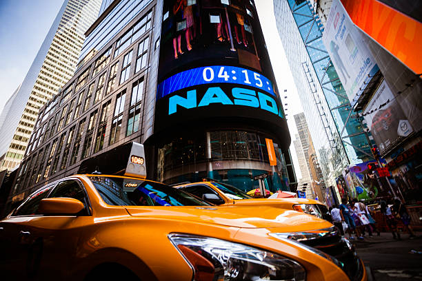 Yellow Taxi in Times Square of New York City, Manhattan New York City, United States - September 12, 2013: Yellow taxis  under the Nasdaq Sign surrounded by colorful advertisement neon signs and lot of people walking by guinness photos stock pictures, royalty-free photos & images