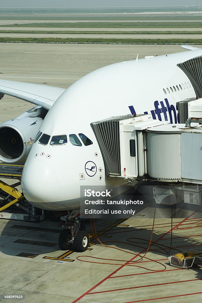 Airbus 380 Shanghai, China - October 11, 2013: a Lufhtansa A380 docked in the apron of Shanghai Pudong International Airport connected to passenger fingers. Air Vehicle Stock Photo