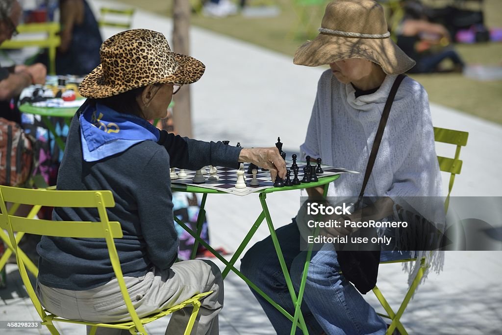 Deux femmes plus âgées jouer aux échecs dans un parc public - Photo de Parc public libre de droits