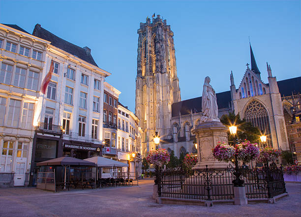 Mechelen, Belgium - September 4, 2013:  St. Rumbold's cathedral in dusk and statue of Margaret of Austria.