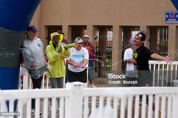 Hombre De Corredor Con Pistolas De Agua Se Se Salpicó Con La At Finish Line Foto de stock y más banco de imágenes de Adulto joven