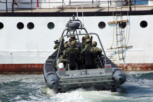 Den Helder, The Netherlands - July 7, 2012: Dutch Marines about to enter a ship during an anti piracy demonstrion at the Dutch Navy Days on Naval base Den Helder.