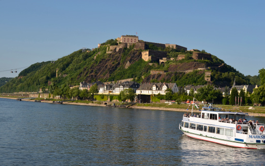 Koblenz, Germany - May 29th 2011: fortress Ehrenbreitstein and cable car across the Rhine river with excursion boat in the Unesco World Heritage area of Rhine valley
