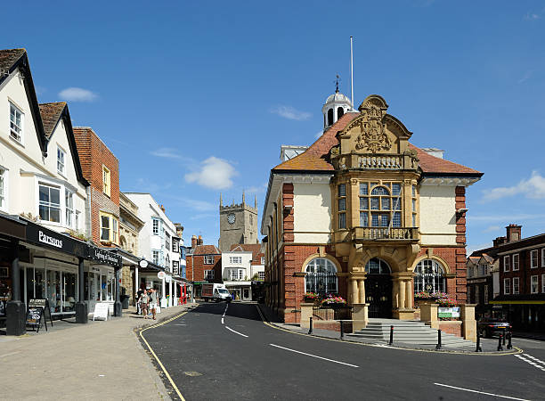 Marlborough Town Hall Marlborough, United Kingdom - September 2, 2013: The eastern end of Marlborough's High Street, in the county of Wiltshire with the Town Hall standing at the junction between Kingsbury Street and Oxford Street. On the left are commercial premises and a bank and in the distance is the tower of the Parish Church of St Mary's. The Town Hall is a Victorian building at the head of the second widest high street in England. Unidentified people. wiltshire stock pictures, royalty-free photos & images