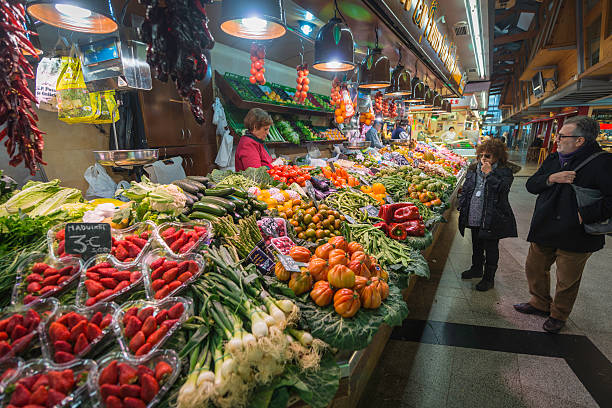 顧客カラフルなフルーツや野菜マーケットの露店ラ・ボケリア・バルセロナスペイン - market stall spain fruit trading ストックフォトと画像