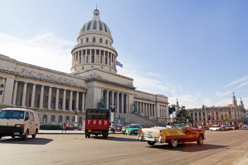 Havana, Cuba - September 7, 2011: Old cars running and parked in front of the Capitol of Havana, Cuba.