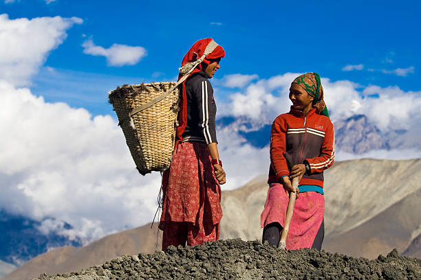 duas mulheres locais estão a cavar o solo. - muktinath - fotografias e filmes do acervo