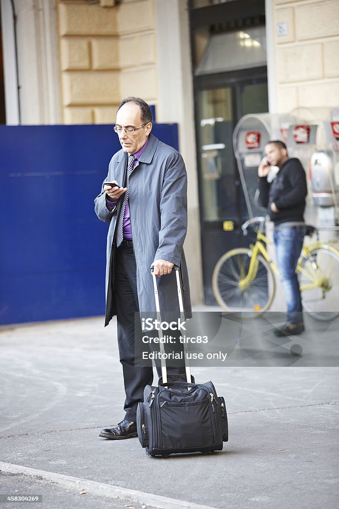 Maschio maturo viaggia al di fuori della stazione ferroviaria Bologna - Foto stock royalty-free di Adulto in età matura