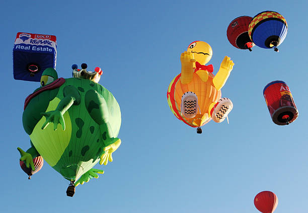 Albuquerque, New Mexico, USA - October 12, 2006:  Hot air balloons in special shapes - frog prince, turtle with sneakers, Alpo dogfood can, the ReMax square balloon, and others lift off at sunrise at the Albuquerque International Balloon Fiesta - the largest such festival in the world. It started in 1972 and takes place in early October, lasting 9 days. Starting with just 21 balloons, the number rose to 1019 in 2000 and eventually had to be limited first to 750, then to 600. Over 100 pilots are from foreign countries. The specially shaped balloons are the most popular feature of the festival.