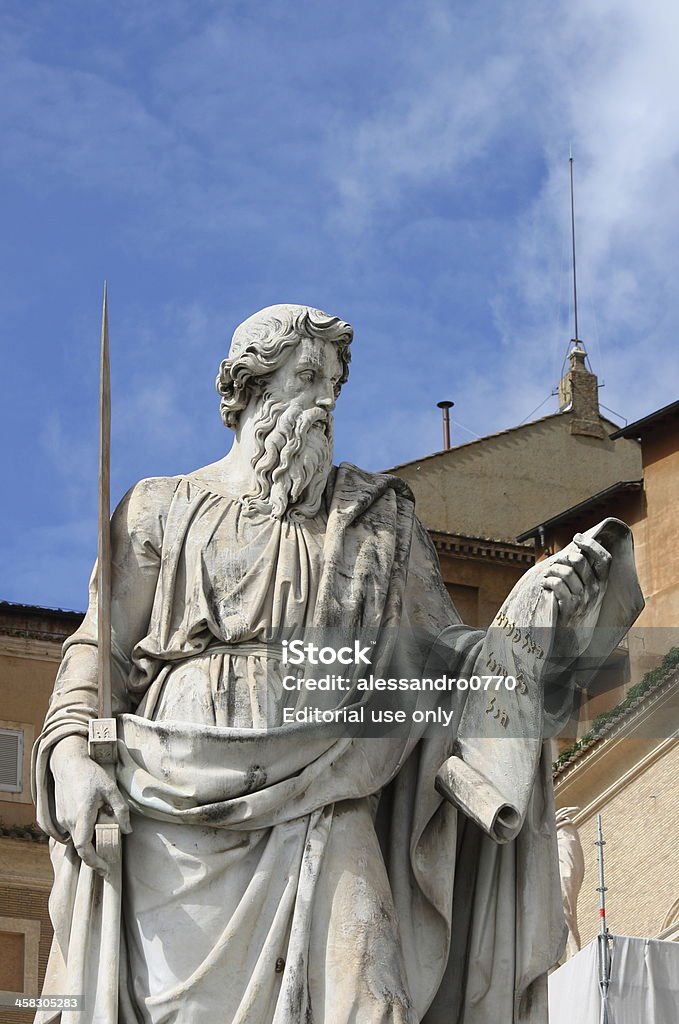 Statue of Saint Paul the Apostle in Vatican Vatican, Vatican City State - March 10, 2013: Statue of Saint Paul the Apostle carved by Adamo Tadolini in front of Saint Peter Basilica with the chimney of Sistina Chapel on the background Statue Stock Photo
