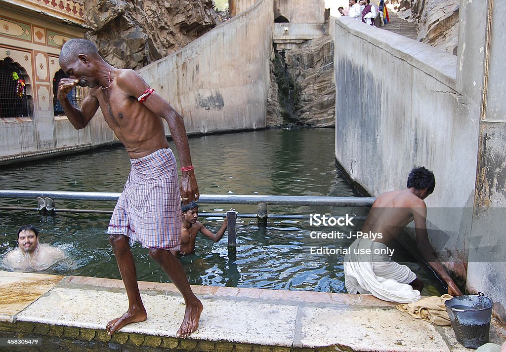 Hombres bañándose en sagrado agua de Galtaji Temple. - Foto de stock de Adulto libre de derechos