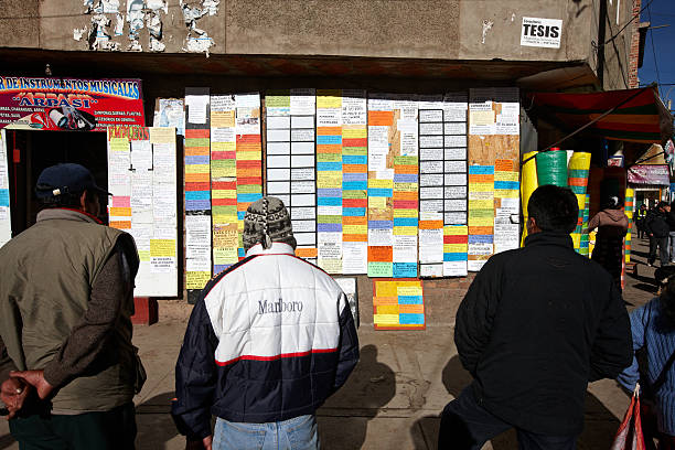 Puno, Peru - May 28, 2013: Peruvians in the city of Puno looking for casual work in the morning by reading the notes posted on a wall in the city centre