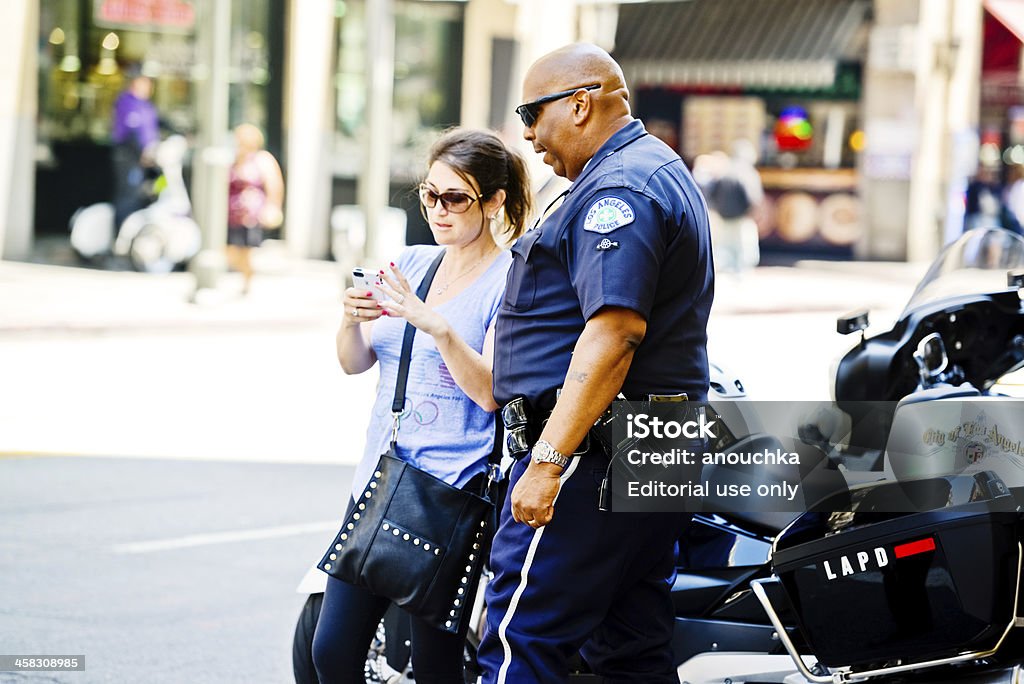 Policeman aiutando donna a Los Angeles street - Foto stock royalty-free di Forze di polizia