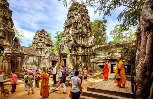 Angkor Wat, Cambodia - November 26, 2012: Many Tourists and monks between historic ruins of Angkor Wat in Cambodia.
