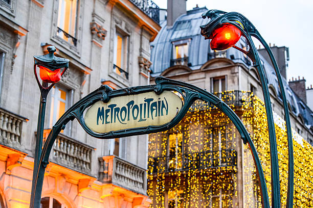 Paris Metro Sign with Christmas Lights on background Paris, France  - December 28, 2012: Paris Metro Sign with beautiful Christmas lights decoration on building on background paris metro sign stock pictures, royalty-free photos & images