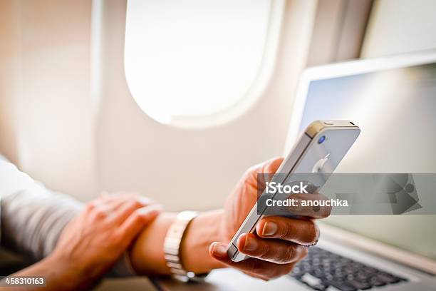 Frau Mit Iphone 4s Und Laptop Im Flugzeug Während Flug Stockfoto und mehr Bilder von Apple Computer