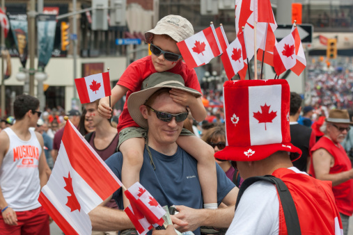Ottawa, Canada - July 1, 2013: A man buying Canadian flags for his family during Canada Day in downtown Ottawa, Ontario.