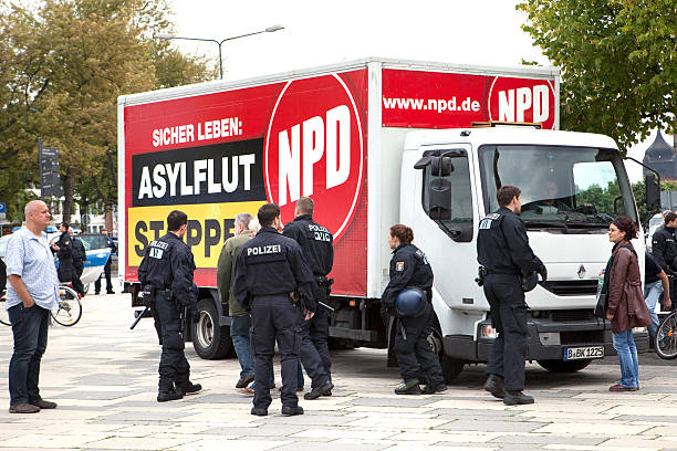 NPD Election campaign, Wiesbaden Wiesbaden, Germany - August 26, 2013: Police protection for NPD Election campaign truck in the city of Wiesbaden. Founded in 1964 the NPD is a German nationalist party, its agitation is racist, antisemitic, revisionist. Because of its activities against the constitutional order the party is under observation of the Verfassungsschutz (German Federal Intelligence agency) national democratic party of germany stock pictures, royalty-free photos & images