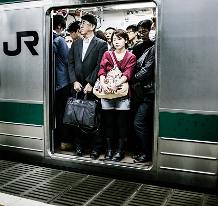 Tokyo, Japan - October 29, 2012: Passengers inside Japan Railways train in Tokyo Japan. Accounting the subway lines and all the other railways that operate in Tokyo 40 million people travel with this kind of transportation everyday in the city.