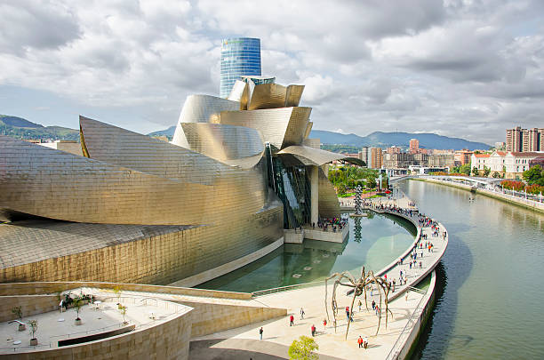 Bilbao, Spain - March 31, 2011: View of Guggenheim Museum Bilbao, designed by the architect Frank Gehry, reflected in Nervion River during dusk. It is a mayor tourist attraction in Bilbao and an architectural milestone of the last century.