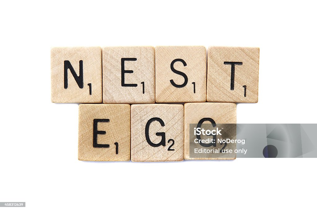 NEST EGG spelled in Scrabble letter tiles West Palm Beach, USA - November 1, 2013: Scrabble game letter blocks spelling out the phrase NEST EGG.  Scrabble is a crossword strategy board game distributed by Hasbro. Alphabet Stock Photo