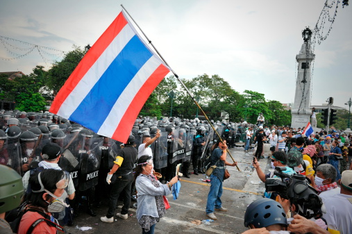 Bangkok, Thailand - November 24, 2012: Anti-government protesters from the nationalist Pitak Siam group rally at a police barricade on Makhawan Bridge. Pitak Siam are calling for the government to be overthrown.
