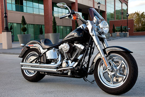 Harley Davidson Fat Boy Motorcycle parked at an office complex Elmwood Park New Jersey, USA - September 29, 2013: This Harley Fat Boy is parked outside an office complex waiting for its owner to arrive. Harley Davidson continues to be the premier brand of motorcycle. harley davidson fat boy stock pictures, royalty-free photos & images