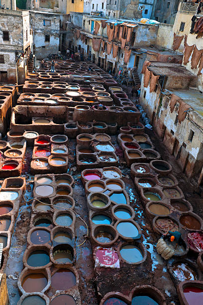 Fez, Morocco - April 3rd, 2012: People working in the famous tannery complex of Fez(Fes) in foul smelling conditions. All natural ancient process.