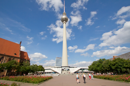 Berlin, Germany - August 6, 2012:  Panoramic view of Berlin TV tower or Fernsehturm and square in front of with pedestrians walking , Alexanderplatz, Germany on August 6, 2012.